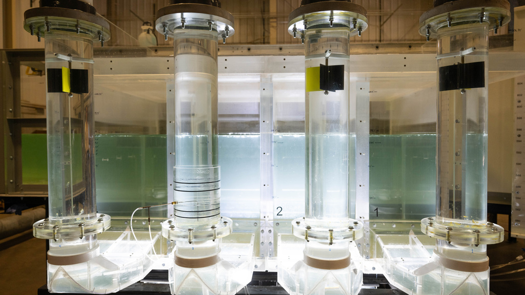 The Bee Branch pump station model illuminated, with four large pumps and a tank of water behind it