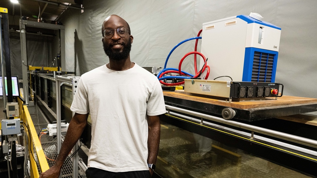 Chukwudum poses and smiles next to the experimental flume