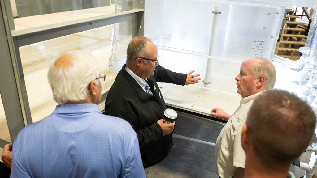 A touring group looks at the Bee Branch model in IIHR's facilities, discussing