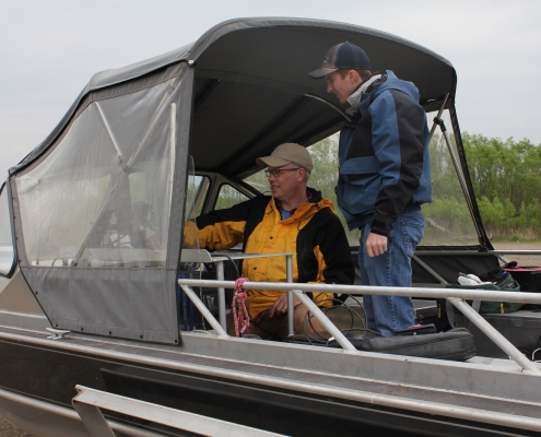 Nate Young and a student work on Bathymetry on a boat