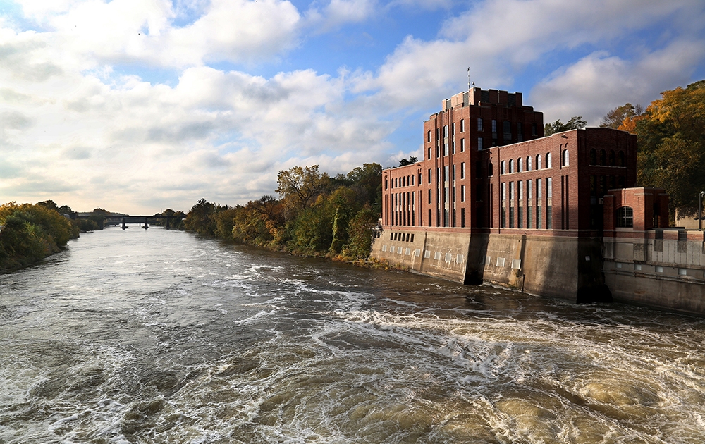 Five-story red brick building, Stanley Hydraulics Lab, set on the banks of the Iowa River in Iowa City.