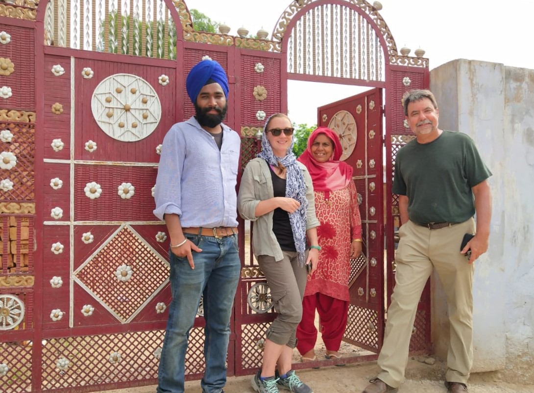 Four people in front of an Indian-style gate