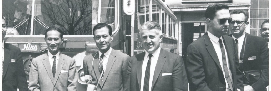 Hunter Rouse and others in front of a bus