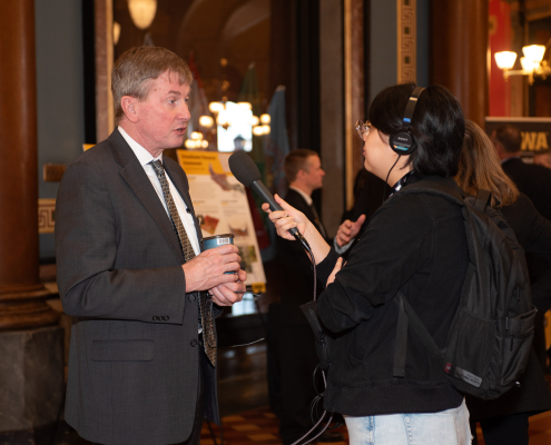 Larry Weber speaks with an interviewer from Capital Dispatch at the IFC Legislative Breakfast